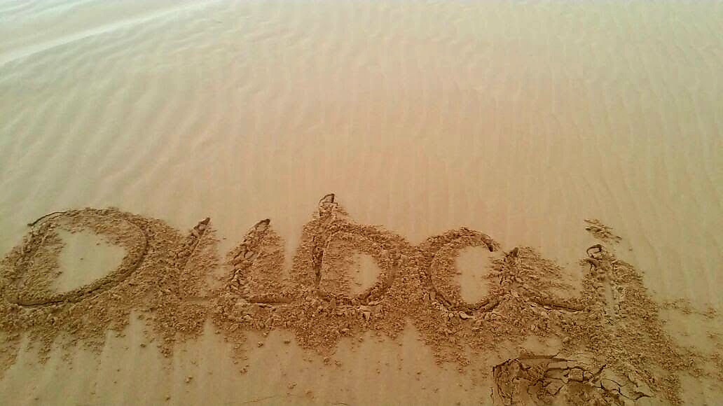 Dubai written in beach sand